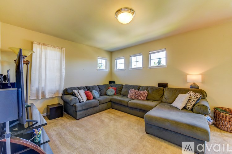 A living room with a grey sectional sofa and a television.