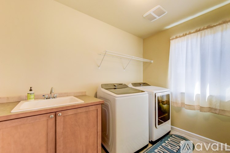 A small kitchen with a sink, a washing machine, and a dryer.