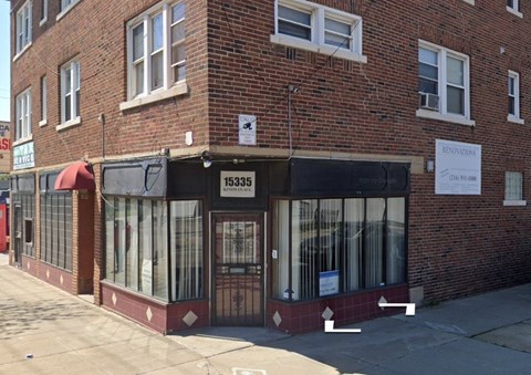 A brick building with a black awning and a sign that reads 15335 KENNEDY ST.
