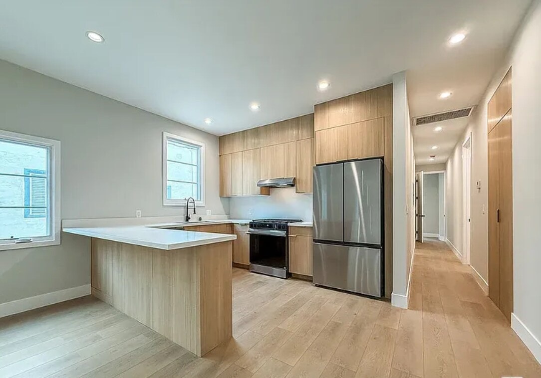A modern kitchen with wooden cabinets and stainless steel appliances.