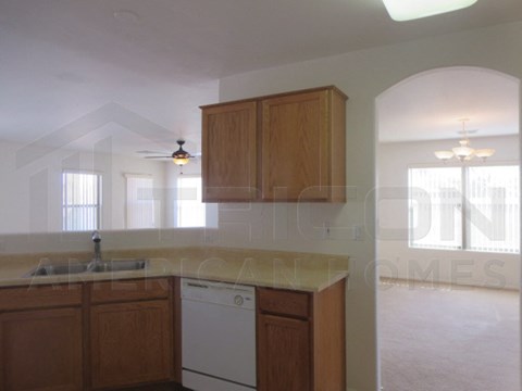A kitchen with wooden cabinets and a white dishwasher.
