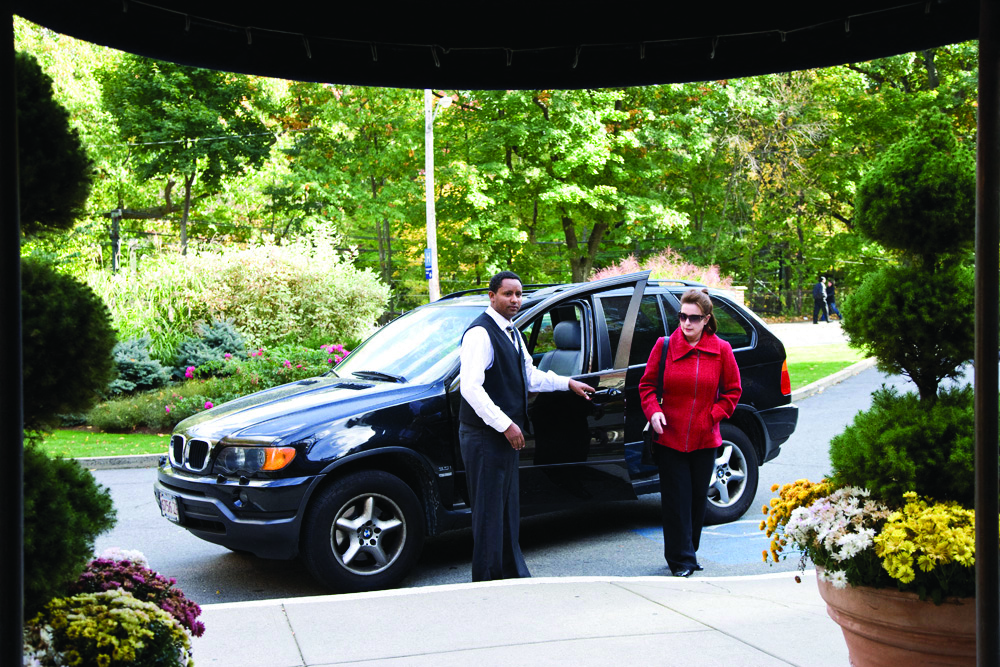 a man and a woman getting out of a black car