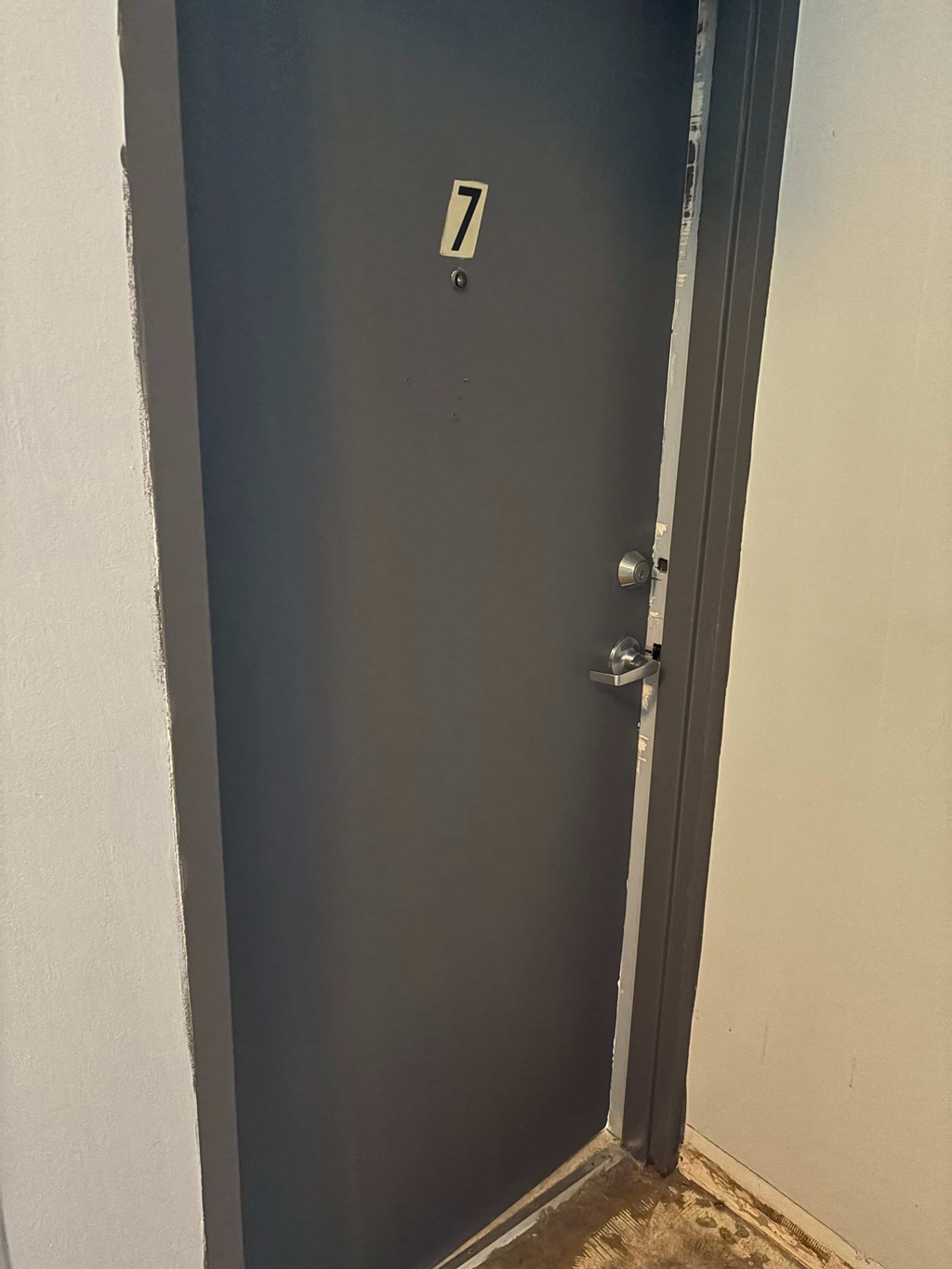 A black door with a silver handle and a number 7 on it.