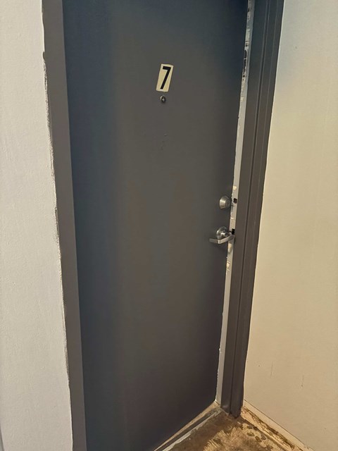 A black door with a silver handle and a number 7 on it.