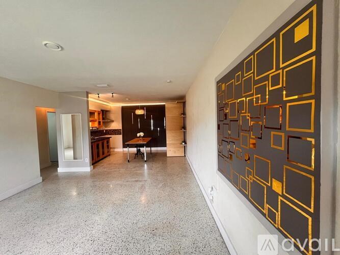 A long hallway with a large painting on the wall.