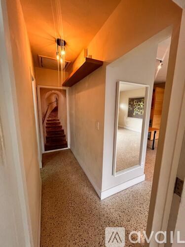 A hallway with a staircase leading to the second floor.