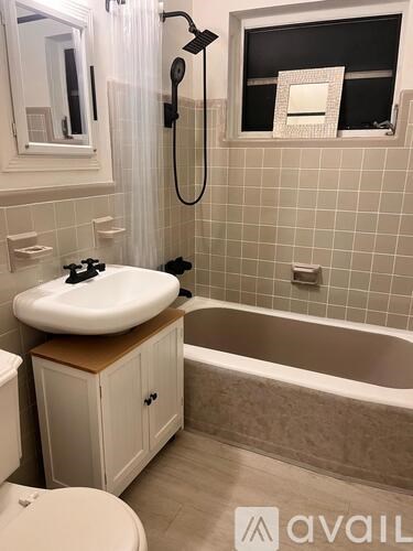 A bathroom with a white sink and a bathtub.
