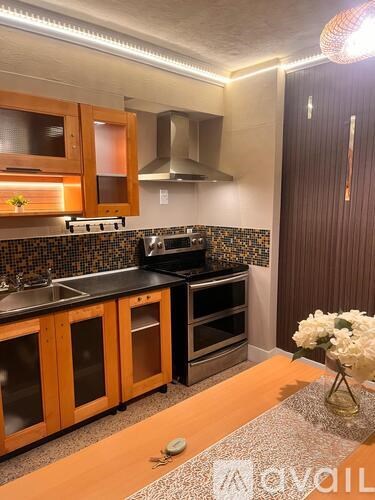 A kitchen with wooden cabinets and a black countertop.