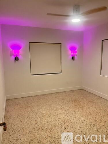 A room with a whiteboard and two purple lights on the wall.