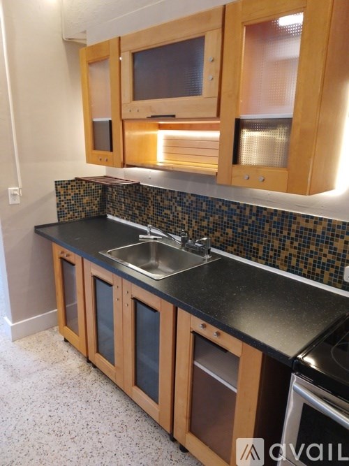 A kitchen with wooden cabinets and a black countertop.