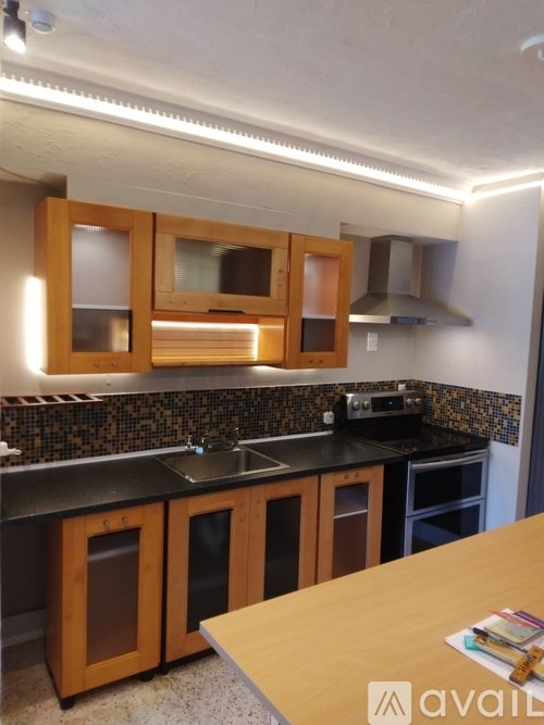 A kitchen with wooden cabinets and black countertops.