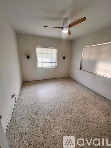 A room with a ceiling fan and a window.