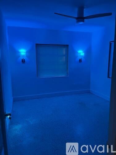 A room with blue lighting and a ceiling fan.