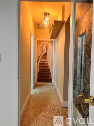 A hallway with a staircase leading to the second floor.