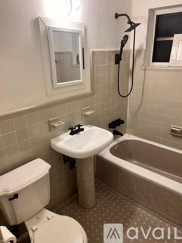 A bathroom with a toilet, sink, and bathtub.