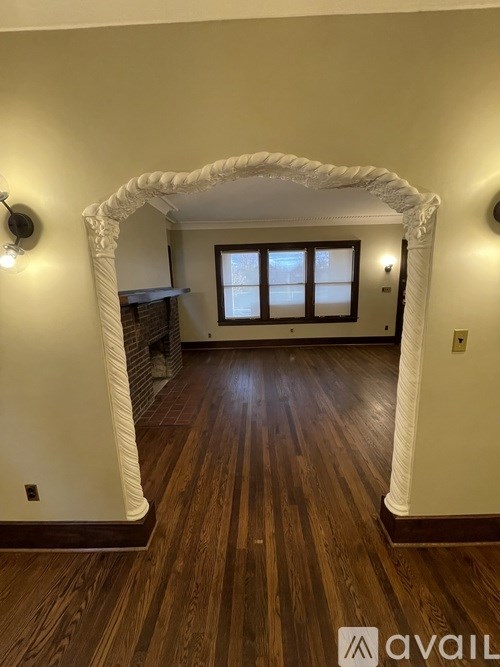 A wall-mounted light fixture with a clear glass bulb is illuminated.