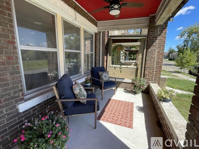 A patio with a red ceiling fan and a blue chair.