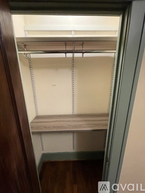 A walk-in closet with a bench and shelves.