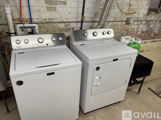 Two white ovens with blue and red pipes in the background.