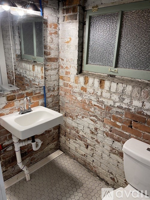 A bathroom with a white sink and a toilet.