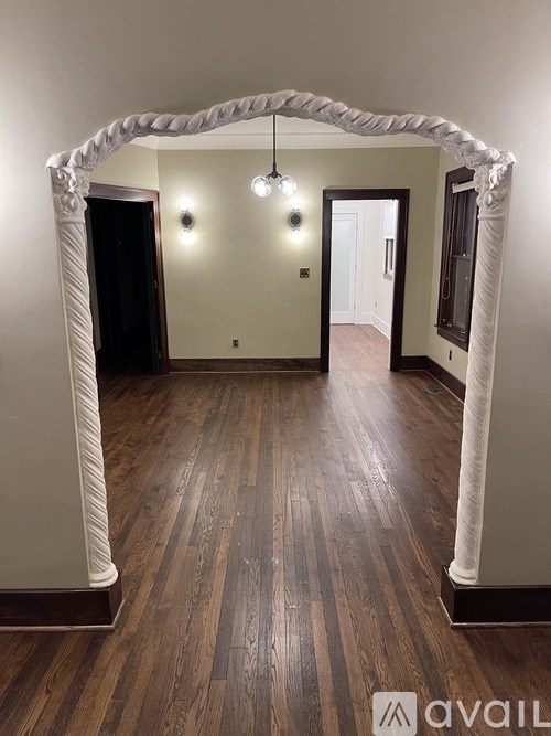 A bathroom with a white sink and grey tiles.