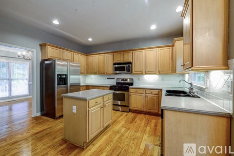 A kitchen with wooden cabinets and a refrigerator.
