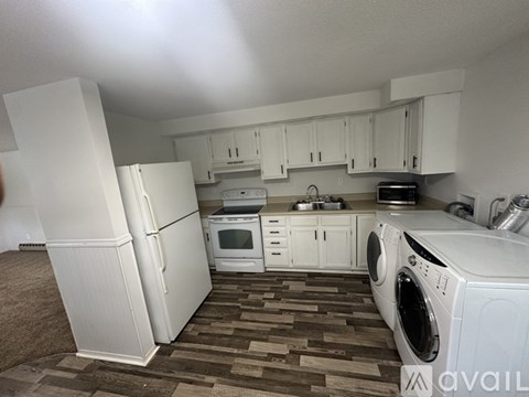 A kitchen with white appliances and cabinets.