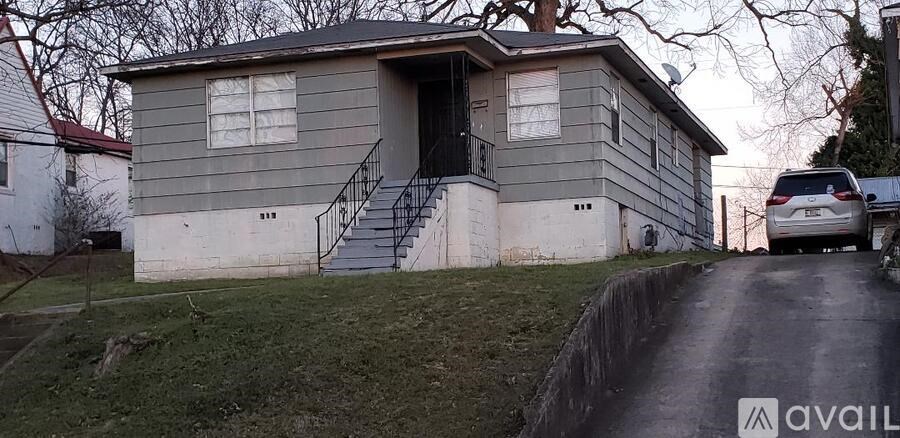 A house with a grey facade and a car parked in front.