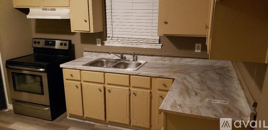 A kitchen with a black stove and a marble countertop.