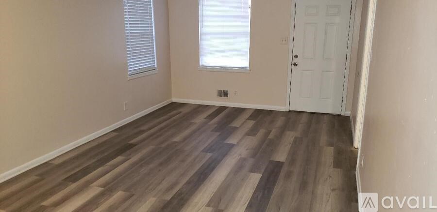 A room with wooden flooring and a white door.