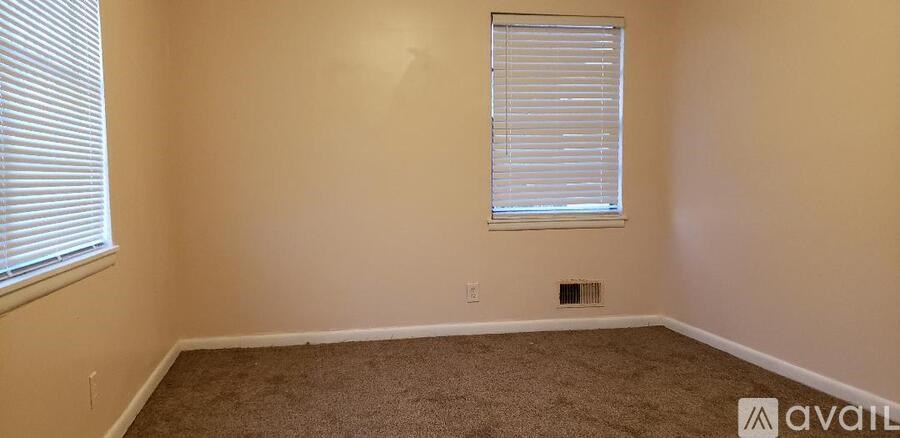 A room with a window and carpeted floor.