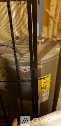 A water heater is installed in a room with a blue pipe.