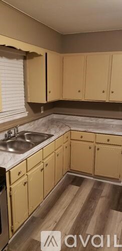 A kitchen with wooden cabinets and a marble countertop.