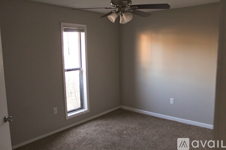 A room with a ceiling fan and a window.