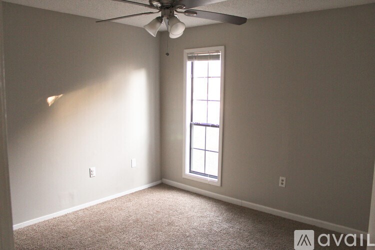 A room with a ceiling fan and a window.