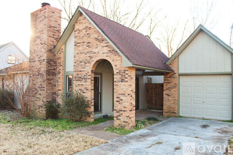 A house with a brick chimney and a garage door.