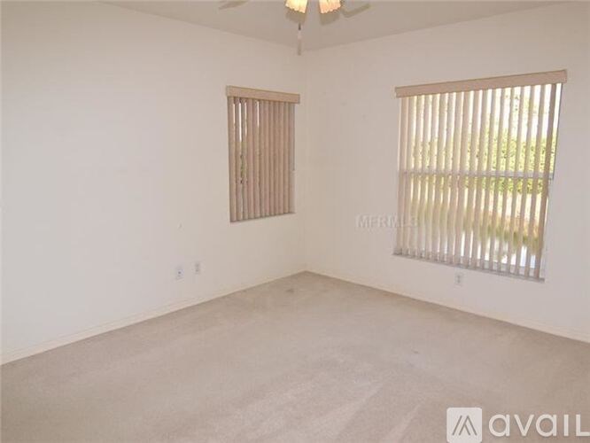 A room with a window and a ceiling fan.