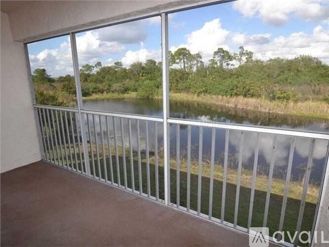 A balcony with a view of a lake and trees.