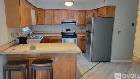 A kitchen with wooden cabinets and a refrigerator.