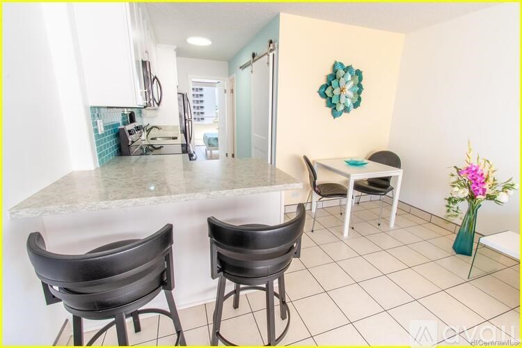 A kitchen with a table and chairs.