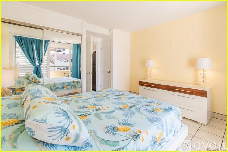 A bedroom with a bed, nightstands, and a window with blue curtains.