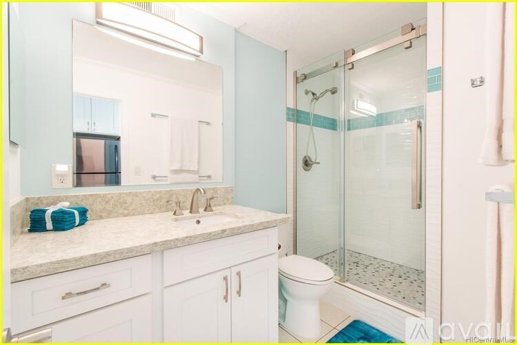 A bathroom with a white toilet, sink, and shower.