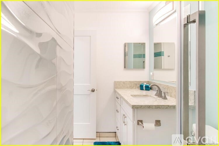 A bathroom with a sink, mirror, and toilet paper roll.