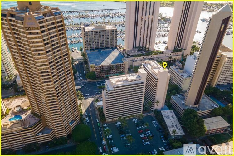 A view of a city with tall buildings and a parking lot.