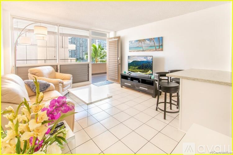 A living room with a couch, a chair, a television, and a painting on the wall.