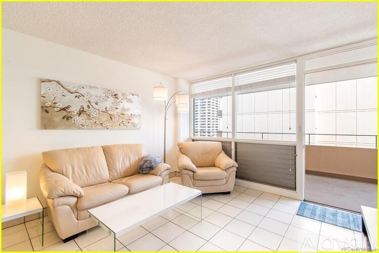 A living room with a tan sofa and a white coffee table.
