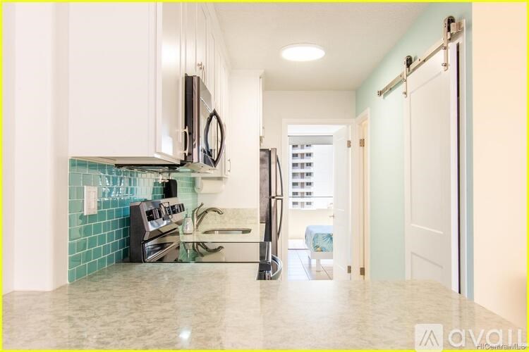 A kitchen with a white counter top and a blue tile backsplash.