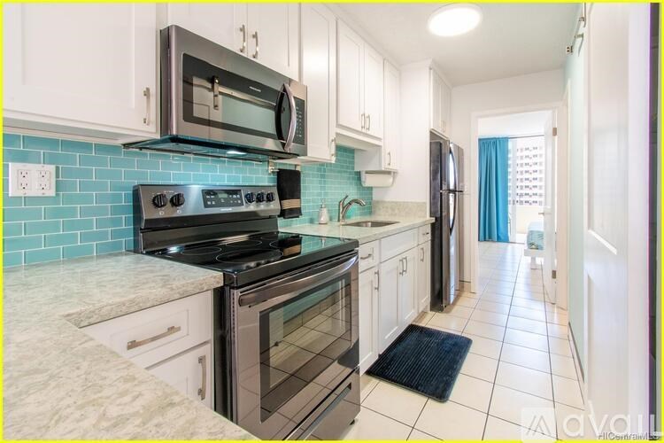 A kitchen with white cabinets and a black stove top oven.