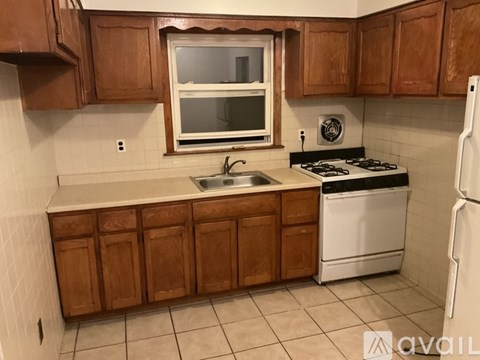 A kitchen with brown cabinets and a white stove.