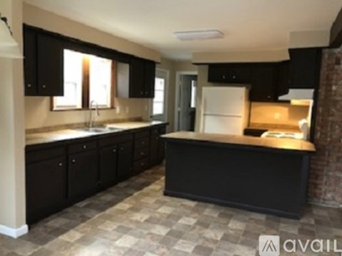 A kitchen with black cabinets and a checkered floor.